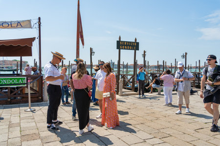 Venice, Italy - May 31 2023: Gondolier approaching a tourists for a gondola ride in Venice.のeditorial素材