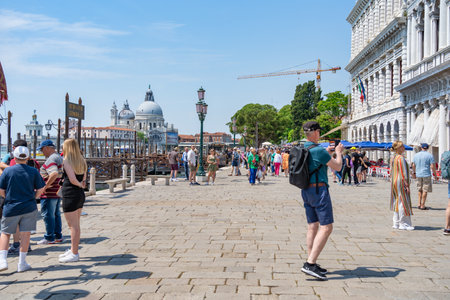 Venice, Italy - May 31 2023: Crowds of tourists strolling on the cobblestone alley near Grand Canal in Venice.のeditorial素材