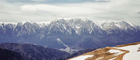 Panoramic scenic view from Baiului Mountains with the snowy peaks of Bucegi Mountains. Carpathians in Romania.の写真素材