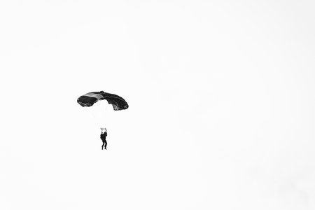 Abstract minimal picture with a parachute jumper on a white background.の写真素材