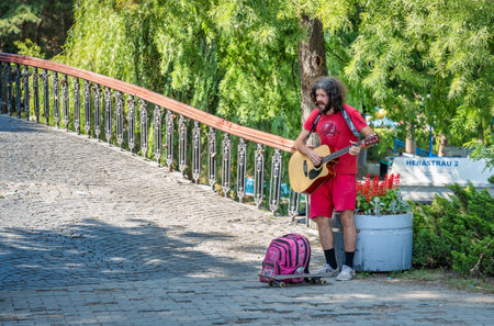 Bucharest, Romania - June 17 2023: Street musician man playing at an acoustic guitar in King Mihai I park ( Herestrau), in Bucharest.のeditorial素材