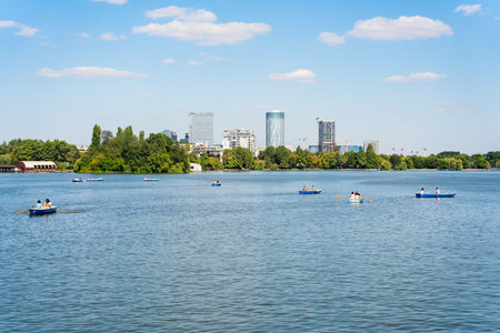 Bucharest, Romania - August 15 2023: Many people in boats paddling on the lake in King Mihai I park (Herestrau). Couple on a romantic gateaway.のeditorial素材