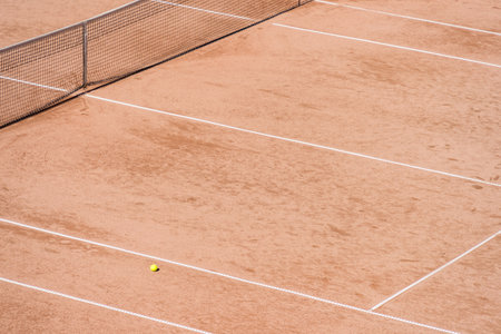 Isolated tennis ball on the clay surface of the tennis courtの写真素材