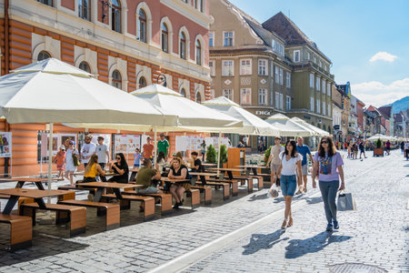 Brasov, Romania - September 02.2023: Tourists and locals strolling on the pedestrian area in the old town center of Brasov.のeditorial素材