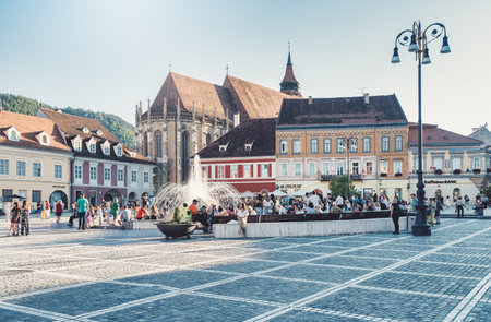 Brasov, Romania - September 02.2023: Tourists and locals strolling on the pedestrian area in the old town center of Brasov. City hall building in Council Square.のeditorial素材