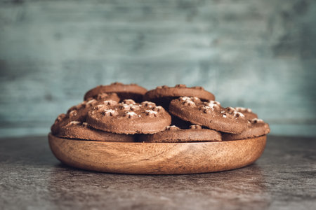 Delicious sweet cocoa cookies biscuits on a wooden plateの写真素材