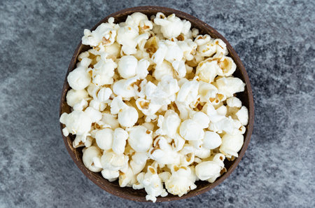 Fresh popcorn snacks in a wooden bowlの写真素材