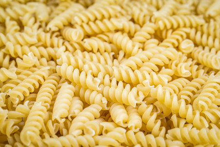 A pile of raw italian fusilli spiral pasta. Texture background.の写真素材