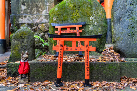 Small shinto place of worship with Torii Gates and inscriptioned stones at Fushimi Inari Taisha temple in Kyoto, Japan. ( Japanese inscriptions translated are different religion blessings)の写真素材