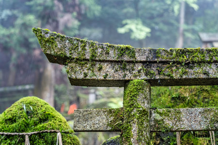 Sacred stones wrapped with rope (Yorishiro) and a torii gate at Fushimi Inari Taisha temple in Kyoto, Japan. ( Translation of the japanese text: religion blessings)の写真素材