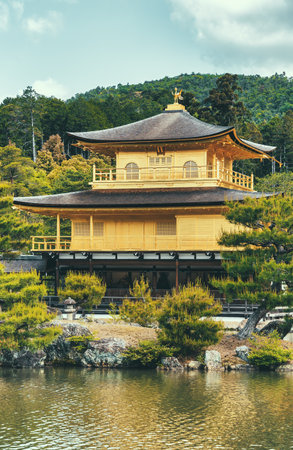 The impressive building structure of Rokuon-ji Kinkakuji (Golden Pavilion) Zen temple overlooking a beautiful water pond, in Kyoto Japan.の写真素材