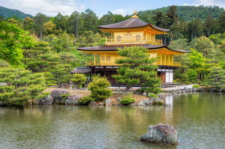 The impressive building structure of Rokuon-ji Kinkakuji (Golden Pavilion) Zen temple overlooking a beautiful water pond, in Kyoto Japan.の写真素材