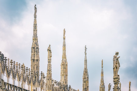View of the gothic ornate spires and statues adorning the rooftop of the Milan Cathedral (Duomo di Milano) in Italy.の写真素材