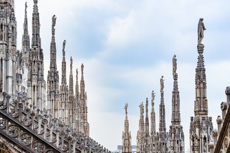View of the gothic ornate spires and statues adorning the rooftop of the Milan Cathedral (Duomo di Milano) in Italy.の写真素材