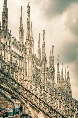 View of the gothic ornate spires and statues adorning the rooftop of the Milan Cathedral (Duomo di Milano) in Italy.の写真素材
