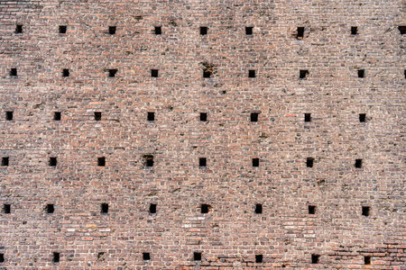 A close-up view with the medieval brick wall part of the historic Sforza Castle (Castello Sforzesco) in Milan, Italy. Brick wall background texture.の写真素材
