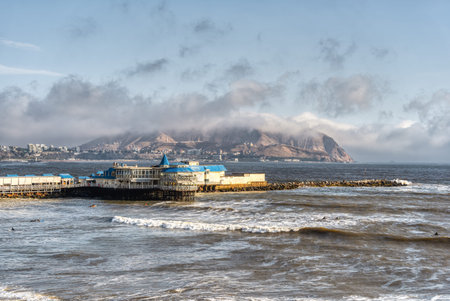 View of a restaurant on the pier in Miraflores with the Pacific Ocean and Chorrillos hills in the background.の写真素材
