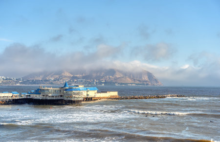 View of a restaurant on the pier in Miraflores with the Pacific Ocean and Chorrillos hills in the background.の写真素材