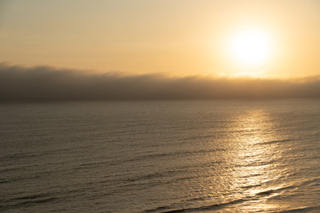 Beautiful golden sunset over the Pacific Ocean coast in Lima, Peru.の写真素材