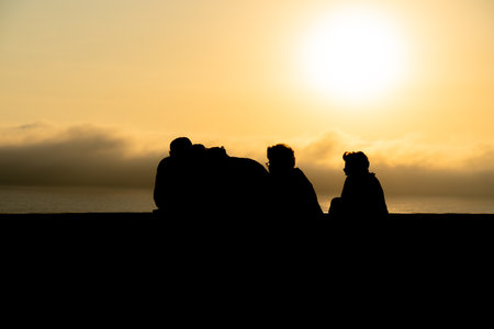 Silhouettes of people admiring the sunset from a Miraflores viewpoint over the Pacific Ocean in Lima, Peruの写真素材