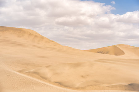 Golden sand dunes of Ica desert under a clear blue sky in Huacachina, Peruの写真素材
