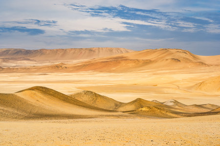 Desert dunes stretch across the arid landscape of Paracas National Reserve in Peru.の写真素材