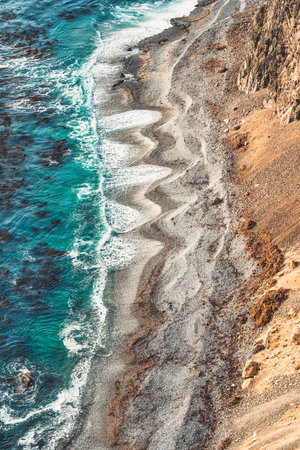 A remote beach bellow the rocky steep cliffs in Paracas National Reserve, Peruの写真素材