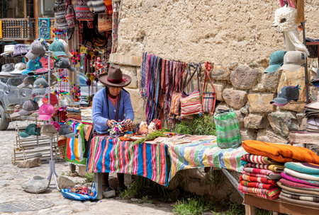 Ollantaytambo, Peru - March 17, 2025: Senior local quechua woman selling Traditional peruvian souvenirs near the entrance of Ollantaytambo Archeological Siteのeditorial素材
