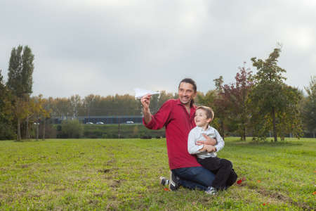 Dad playing with son throwing a paper airplaneの写真素材