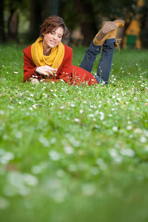 Sexy beautiful serious romantic girl with short hair leaning down on flowers field in autumn dayの写真素材
