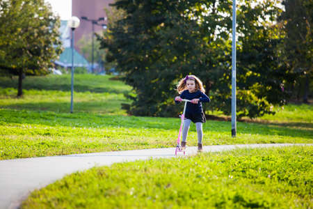 girl playing with scooter in the parkの写真素材