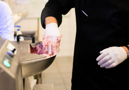 Chef cook preparing meatloaf composition at the grinder machine