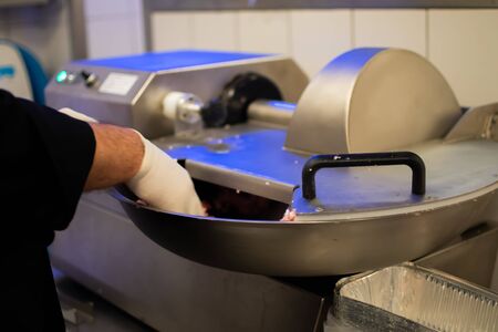 Chef cook preparing meatloaf composition at the grinder machineの写真素材