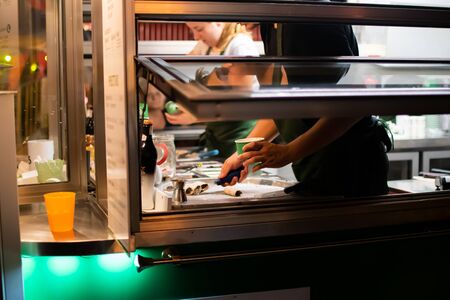 Man preparing ice cream during fast food festivalの写真素材