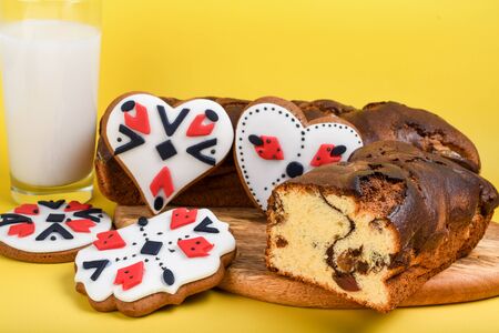 Slices of Romanian sponge cake with red traditional towel with manual stitch on wooden board, Easter painted eggs and home made ginger bread hearts, Authentic Easter Brunch concept.の写真素材