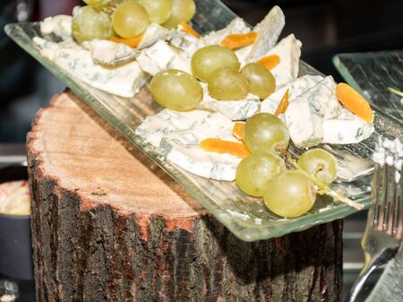 Mix of cheese cuts on a platter, during brunch buffet. Tasty assortment of fresh cheese selection, various types of dairy products, presented during brunch buffet. French or Italian appetizer plattersの写真素材