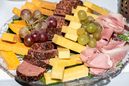 Selection of fresh cuts antipasto: ham, cheese, dried tomatoes and meat appetizers to wine served on a glass plate during brunch, breakfast, banquet or catering event. A variety of fresh canapesの写真素材