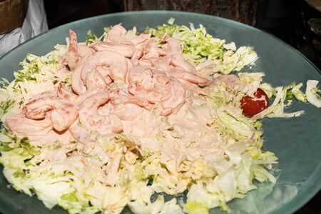 Shrimps salad on green salad leaves bed, brunch buffet specialty dish. Food display during catering or private business event. Fresh seafood served with creamy white sauceの写真素材