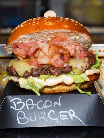 Fresh melting burger ready to eat during fast food festival. Outdoor catering event, brunch or outside dinner party with fast food. Melting cheese and golden bun. Appetizing closeup homemade burgerの写真素材