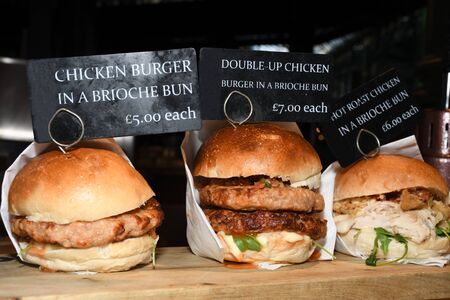 Fresh melting burger ready to eat during fast food festival. Outdoor catering event, brunch or outside dinner party with fast food. Melting cheese and golden bun. Appetizing closeup homemade burgerの写真素材