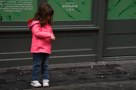 London, United Kingdom, 25th of January 2020: Little girl breaks firecrackers on the ground during Chinese New Year's Celebration 2020 in Londonのeditorial素材