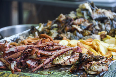 Freshly grilled fish on counter top stall, during seafood festival, street food market. Red sea...