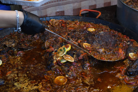 Traditional fish stew being prepared in a rustic bowl over a wood background. Fresh Food Buffet...