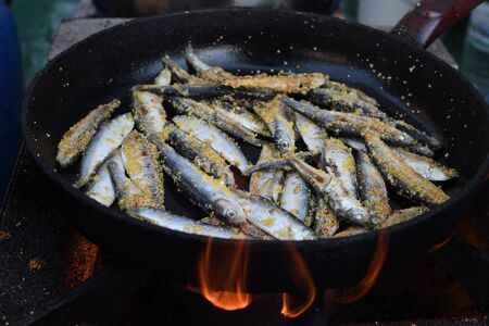 Freshly grilled fish on counter top stall, during seafood festival, street food market. Red sea bass, trout, sword fish, fried golden calamari, diverse seafood variety selection closeup, top view.の写真素材