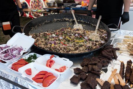 Seafood paella cooked in a large pan wok, street food festival. Mexican fiesta national day dish specialty. Live cooking station. Fresh Food Buffet Brunch Catering Dining Eating Party Sharing Conceptの写真素材
