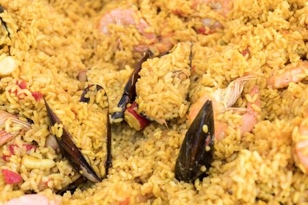 Seafood paella cooked in a large pan wok, street food festival. Mexican fiesta national day dish specialty. Live cooking station. Fresh Food Buffet Brunch Catering Dining Eating Party Sharing Conceptの写真素材