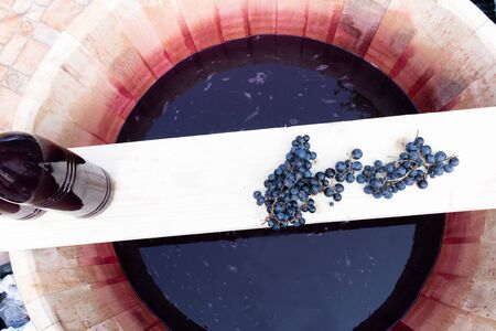 Freshly squeezed grape juice during food and wine festival. Traditional Romanian sweet drink, sugar free, intense red colorの写真素材