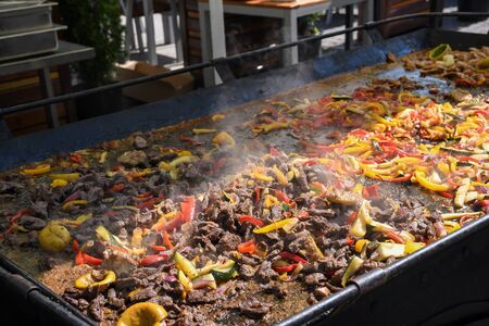 The process of preparing a quesadilla, traditional Mexican dish. Outdoor outside setting, chef cooking during food festival, authentic street food. Black gloves tasty ingredients. Cook flips over pitaの写真素材