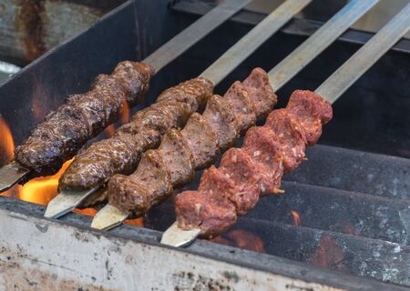 Adana kebab (ground lamb minced meat on skewer on grill over charcoal).Chef preparing traditional authentic Turkish shaworma. Middle eastern cuisine. Handmade specialty street food market with spicesの写真素材