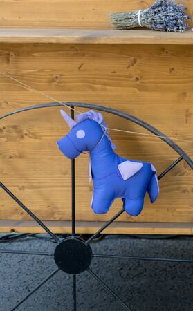 Purple unicorn toy hanging on a rope on a van during food festivalの写真素材